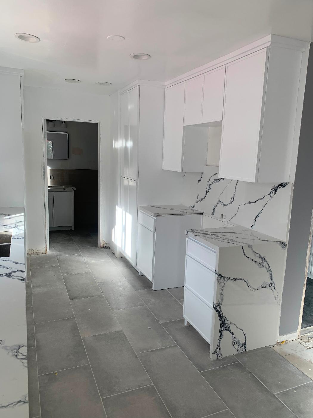 Finished bathroom with a white vanity, toilet, and warm wood-look flooring