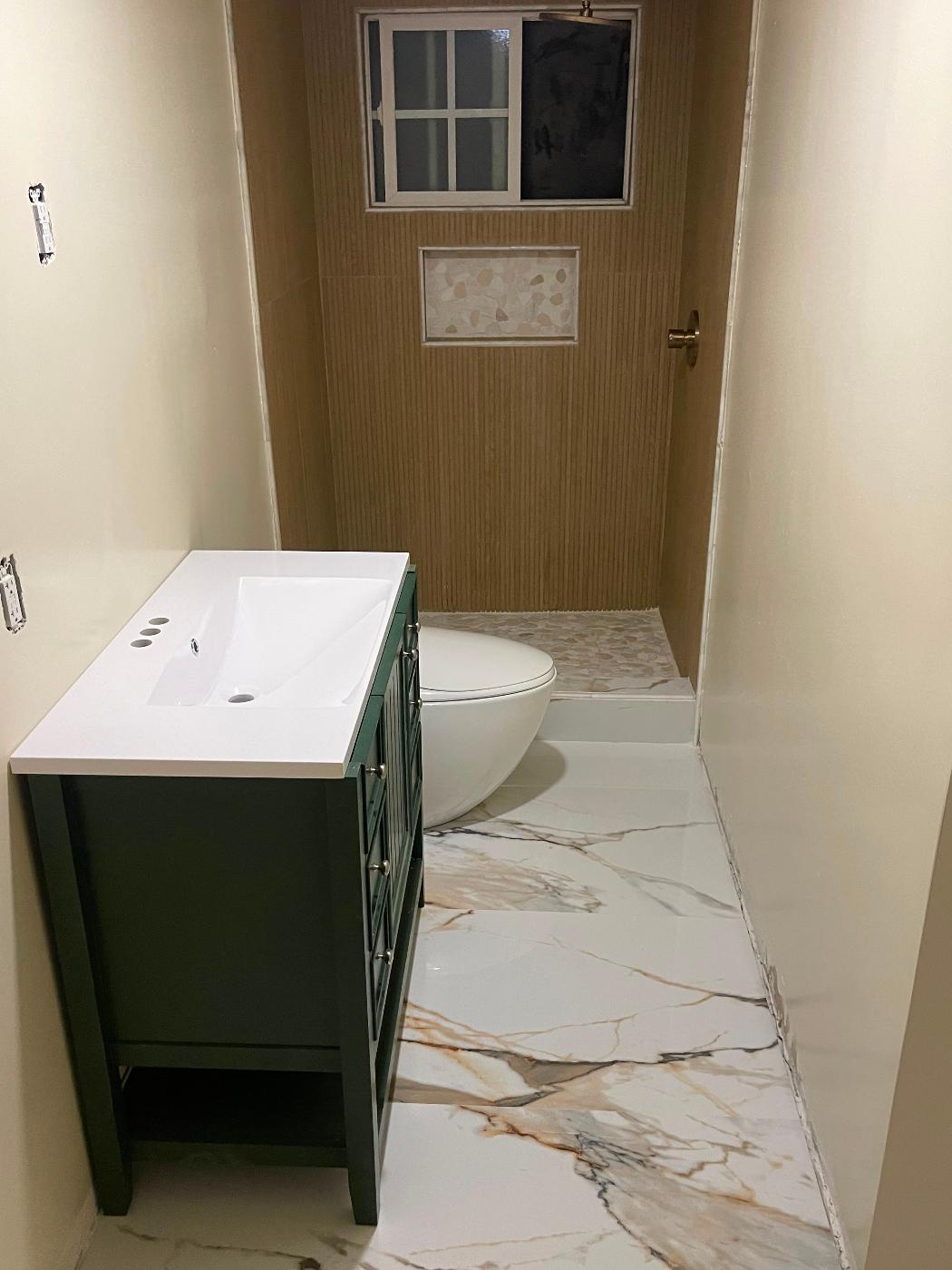 Finished bathroom with a white floating vanity and polished marble-look flooring