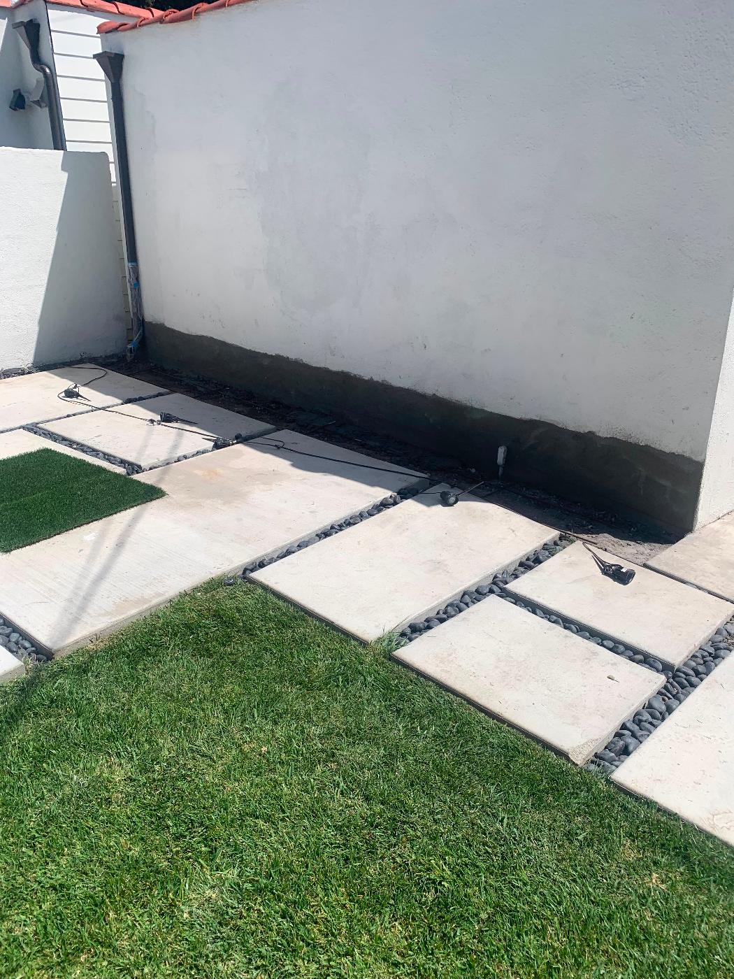 Completed backyard with new paver hardscape, fresh sod, and clean exterior lines